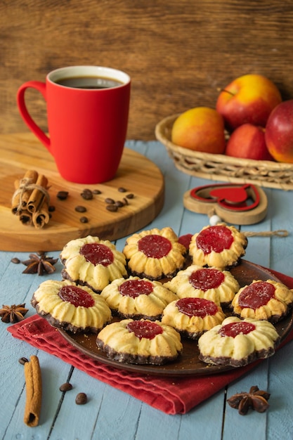 composition tasse de café et biscuits rouges petit-déjeuner sur un fond en bois