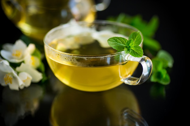 Composition avec tasse de thé au jasmin et fleurs isolées sur fond noir