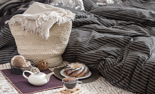 Composition d'une tasse de thé, d'une théière et de gâteaux faits maison dans une chambre douillette.