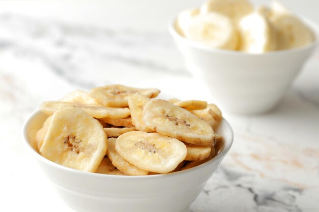 Composition avec des tranches de banane sucrée, vue de dessus avec un espace pour le texte. Fruits secs comme collation saine. Petit-déjeuner sain