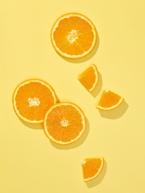 Composition de tranches d'orange fraîche isolée sur fond jaune, vue de dessus