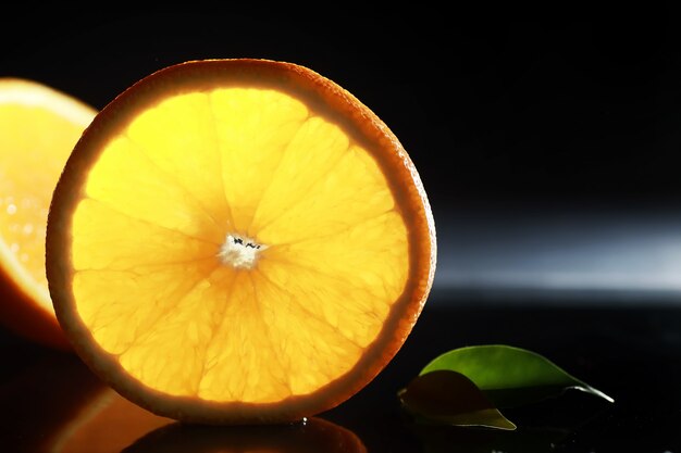 Composition avec des tranches d'orange et de pamplemousse sur fond noir