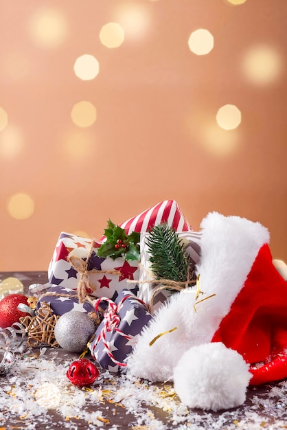 Composition de vacances de Noël avec chapeau rouge du père Noël et coffrets cadeaux sur fond de bois