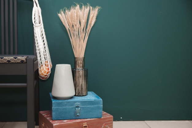 Composition de vase en céramique avec bouquet d'épillets secs sur table en bois sur fond vert Décoration élégante Design d'intérieur moderne