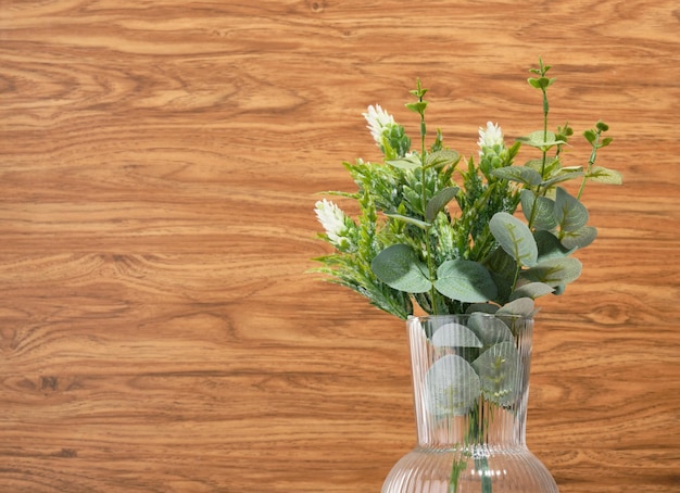 Composition végétale de la forêt verte dans un beau vase en verre sur un fond en bois Copier l'espace pour le texte