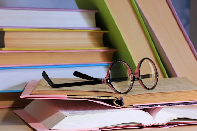 Composition avec verres et livres sur table sur fond clair