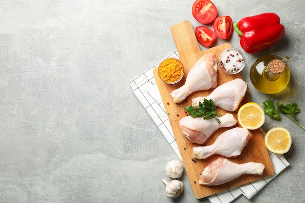 Composition avec de la viande de poulet crue sur un espace gris, vue de dessus