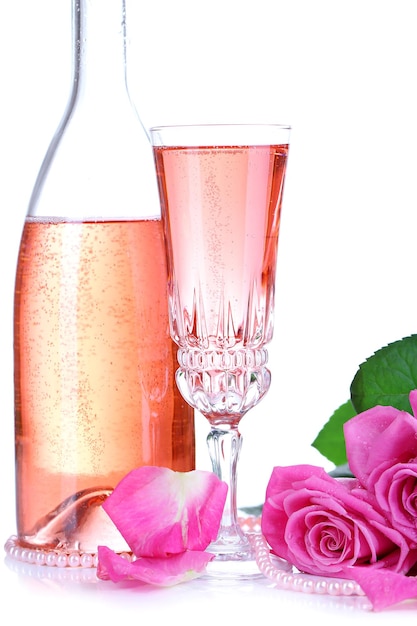 Composition avec vin pétillant rose en verre, bouteille et roses roses isolées sur blanc