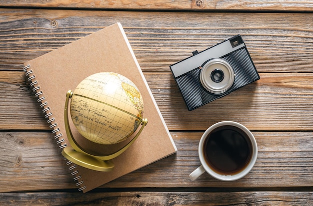 Composition de voyage avec caméra globe bloc-notes et vue de dessus de tasse à café