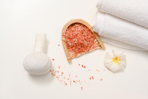 Compositions de spa avec serviettes de boule de massage au sel de l'Himalaya et fleur de frangipanier sur fond blanc