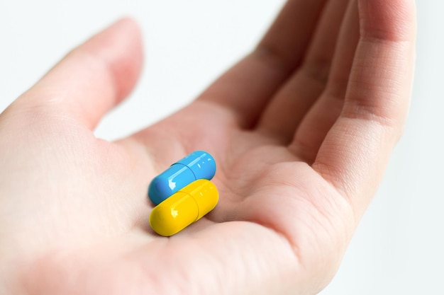 Comprimé bleu et jaune à portée de main Capsules médicales ukrainiennes Soins médicaux humanitaires