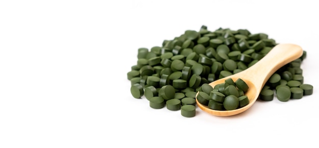 Comprimés d'algues spiruline avec cuillère isolé Concept de santé de vitamines de suppléments nutritionnels