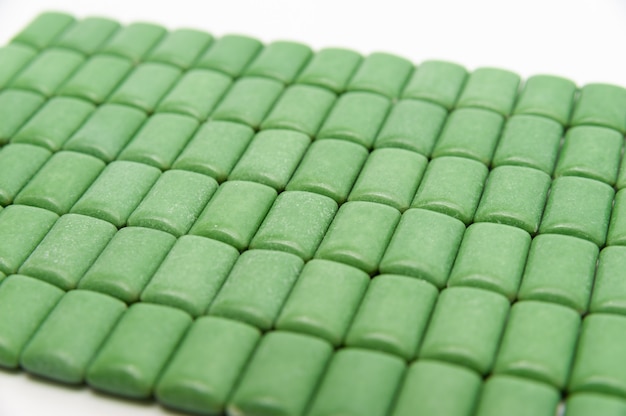 Comprimés de chewing-gum à la menthe verte alignés isolé sur fond blanc