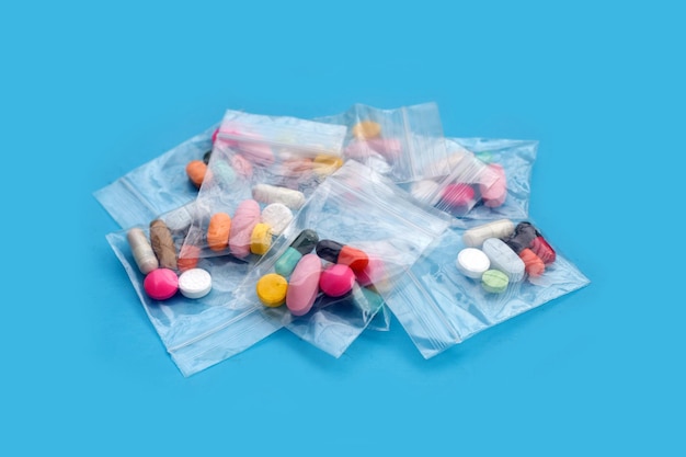 Comprimés colorés avec des capsules et des pilules dans des sacs en plastique à fermeture à glissière