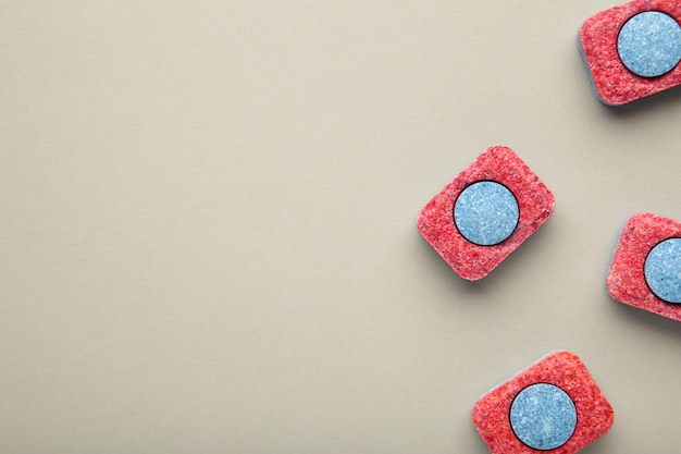 Comprimés rouges et bleus pour lave-vaisselle Détergents pour l'hygiène domestique Capsules pour lave-vaisselle sur fond gris