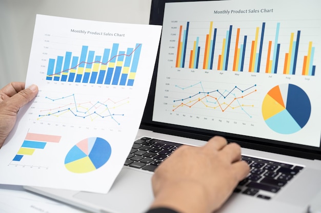 Comptable asiatique travaillant et analysant la comptabilité de projet de rapports financiers avec graphique graphique et calculatrice dans le concept moderne de finance et d'entreprise de bureau