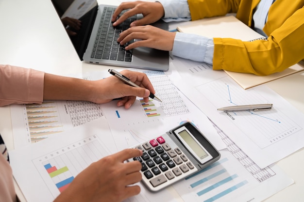 Comptable pointant sur un ordinateur portable pour l'équipe de réunion dans la salle de bureau. concept finance et comptabilité