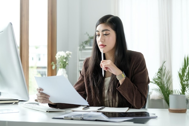 Photo comptable professionnelle vérifiant les rapports financiers dans un bureau moderne