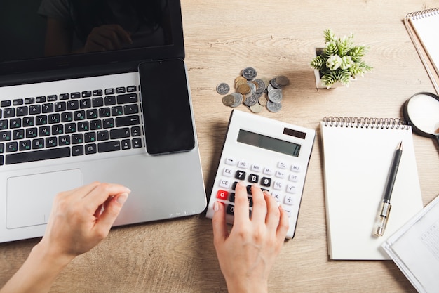 Compte l'argent sur une calculatrice sur le bureau