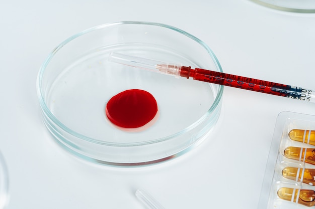 Compte-gouttes en verre et boîte de Petri sur table de laboratoire