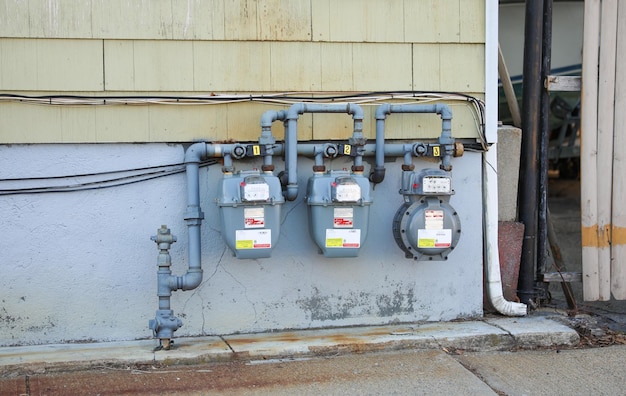 Un compteur de gaz est sur le mur d'une maison.