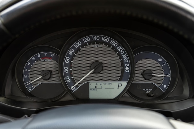 Photo un compteur de vitesse de voiture noir. vue rapprochée du tableau de bord d'une voiture.