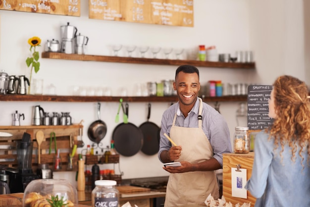 Photo comptoir barista et femme avec commande au café avec notes souriantes et service pour une bonne expérience client écriture de serveur et dame avec décision de choix ou choix dans le menu du restaurant deli ou du dîner