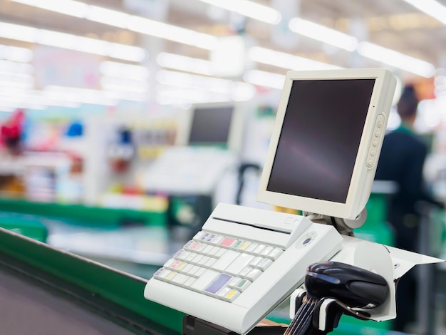 Un comptoir de caisse vide avec un terminal dans un supermarché