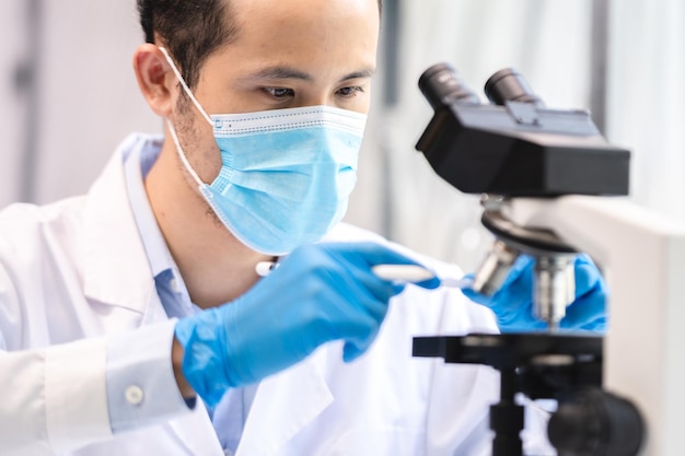 Concentration de chercheur professionnel à l'aide d'un microscope dans un technicien de laboratoire de médecine chimique travaillant avec un équipement de technologie des sciences médicales pour une expérience de biotechnologie ou de biologie