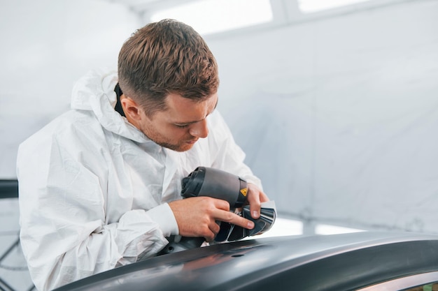 Concentré au travail L'homme en uniforme est dans le service automobile