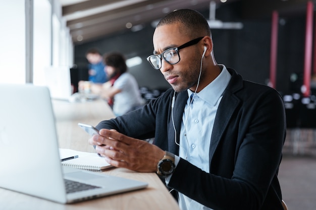 Concentré beau jeune homme d'affaires a reçu de mauvaises nouvelles sur le smartphone pendant le processus de travail