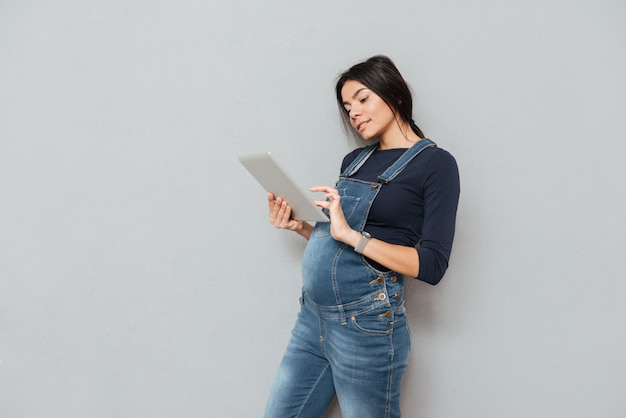 Concentré de femme enceinte à l'aide de la tablette tactile