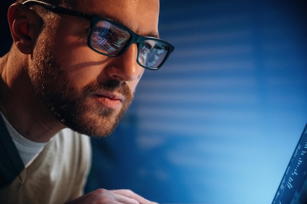 Concentré sur le travail Programmateur masculin travaille à l'intérieur avec un ordinateur portable