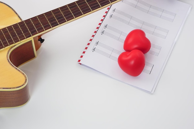 Concentrez le manche de la guitare acoustique et brouillez les notes de musique et le coeur rouge Aimez la musique et le concept d'apprentissage