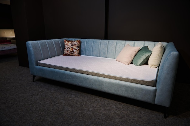 Concentrez-vous sur un canapé-lit en velours doux turquoise avec matelas orthopédique exposé à la vente dans un magasin de design de meubles