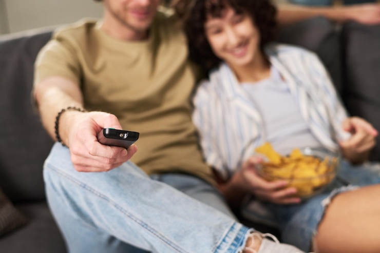 Photo concentrez-vous sur la main du jeune homme reposant tenant la télécommande
