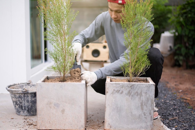 Concentrez-vous sur les mains de l'homme mettant le sol dans des pots Jardinage devant la maison