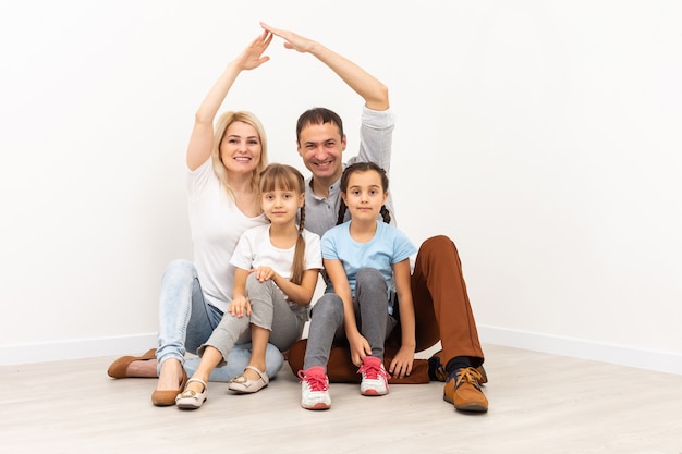 concept abritant une jeune famille. Père de mère et enfants dans la nouvelle maison avec un toit