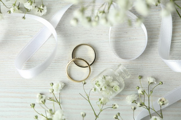 Concept d'accessoires de mariage avec des anneaux de mariage sur fond de bois blanc