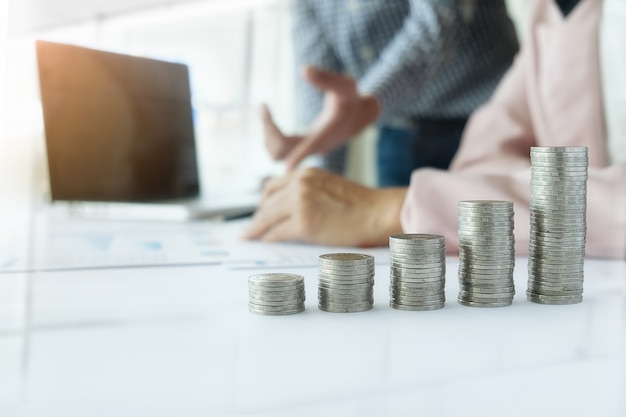 Photo concept d'affaire. des lignes de pièces de monnaie pour le concept financier et bancaire avec des hommes et des femmes d'affaires. une métaphore du conseil financier international.