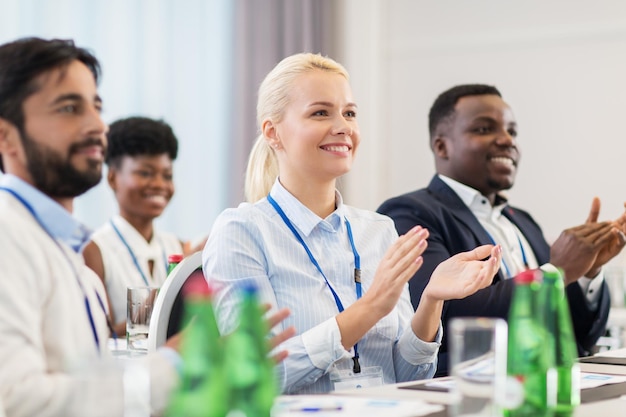 Photo concept d'affaires et d'éducation - un groupe de personnes heureuses applaudissant lors d'une conférence internationale