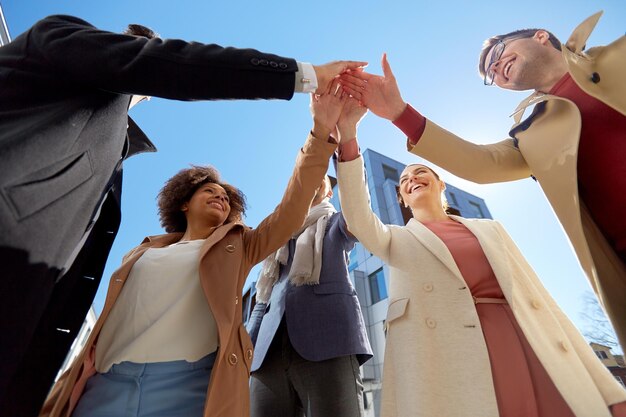 Photo concept d'affaires, de succès et de geste - groupe international de personnes ou d'étudiants donnant le high five dans la rue de la ville