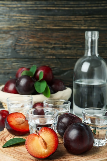 Concept d'alcool avec de la vodka aux prunes sur fond de bois