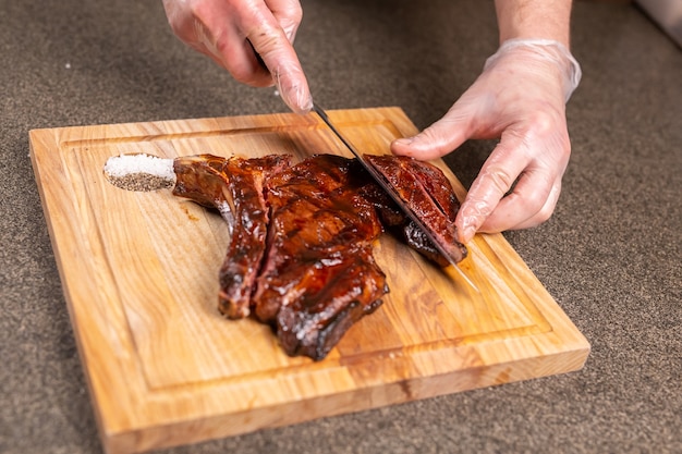 Concept alimentaire, délicieux et artisanal - Homme coupant un steak de cheval.