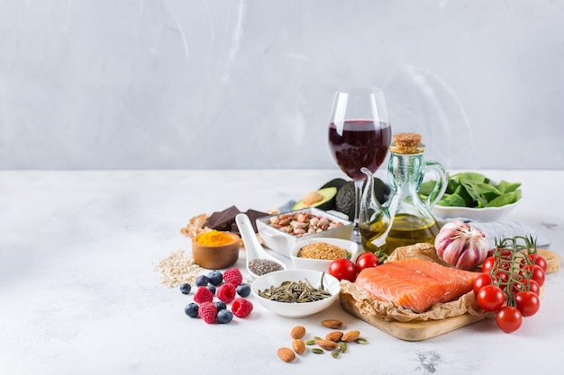 Concept alimentaire équilibré Assortiment d'aliments sains faible en cholestérol épinards avocat vin rouge thé vert saumon tomate baies lin graines de chia curcuma ail noix huile d'olive Copier l'arrière-plan de l'espace