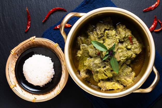 Concept alimentaire Lait de coco thaïlandais Boeuf au curry vert sur fond noir avec espace de copie