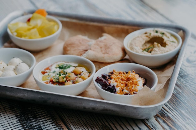 Concept alimentaire et nutritionnel Plat traditionnel d'Israël pour le dîner Plateau de délicieuses betteraves houmous avec noyau d'épices de tomate pain pita fromage de chèvre servi pour vous