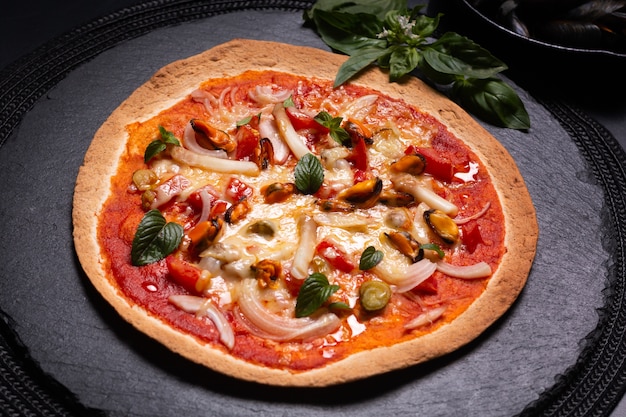 Concept alimentaire Pizza aux fruits de mer Tortilla maison sur plaque de pierre ardoise noire