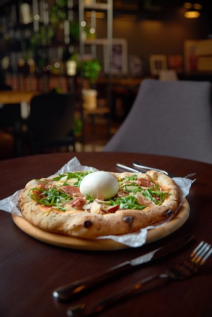 Concept alimentaire. Pizza italienne originale fraîche avec burrata, prosciutto et roquette.