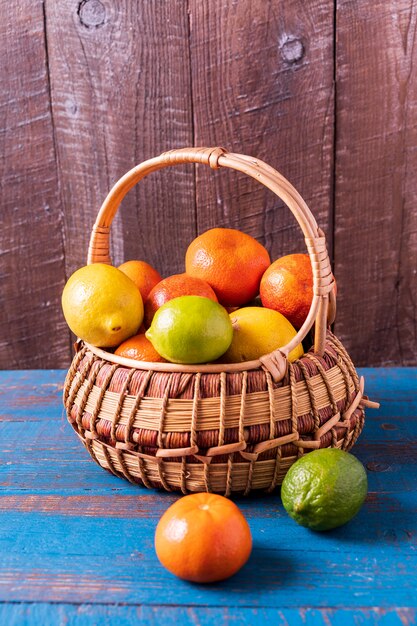 Concept de l&#39;alimentation saine. agrumes dans un panier sur fond en bois